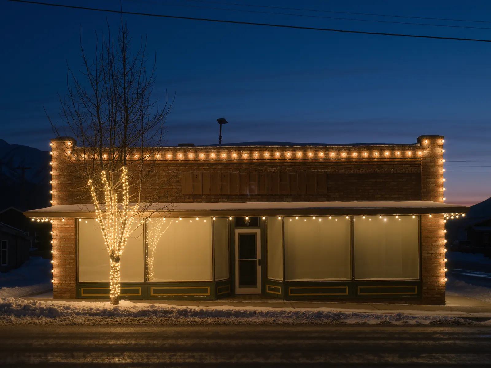 Commercial Christmas light installation on a Calgary storefront lit at night